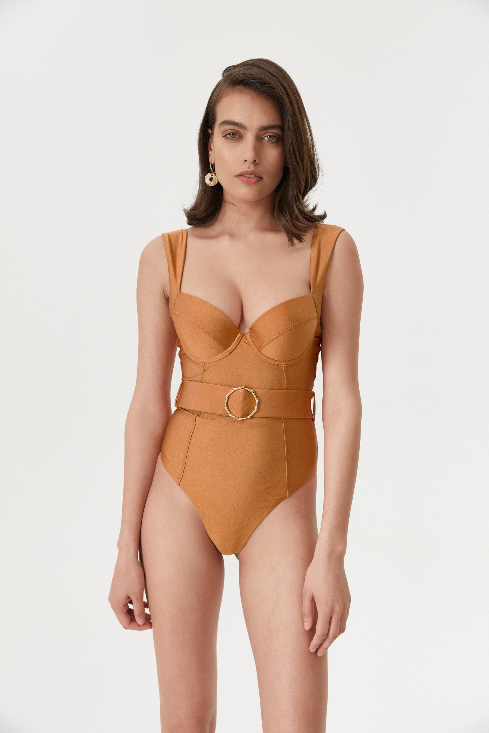 Front view of a female model wearing the Amber Iconic One Piece, facing the camera and showcasing its elegant design in vibrant amber color.